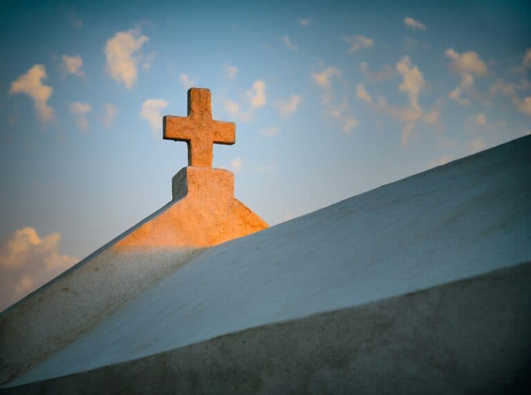 Sunlight falling on a cross on top of a church