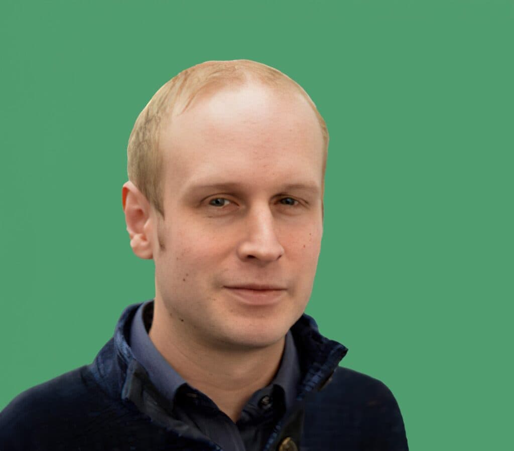 Man standing before a green background