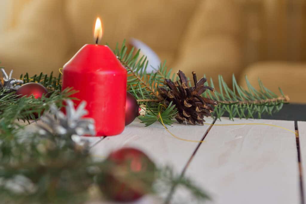 Christmas decoration with fir branches, cones and toys on white wooden background