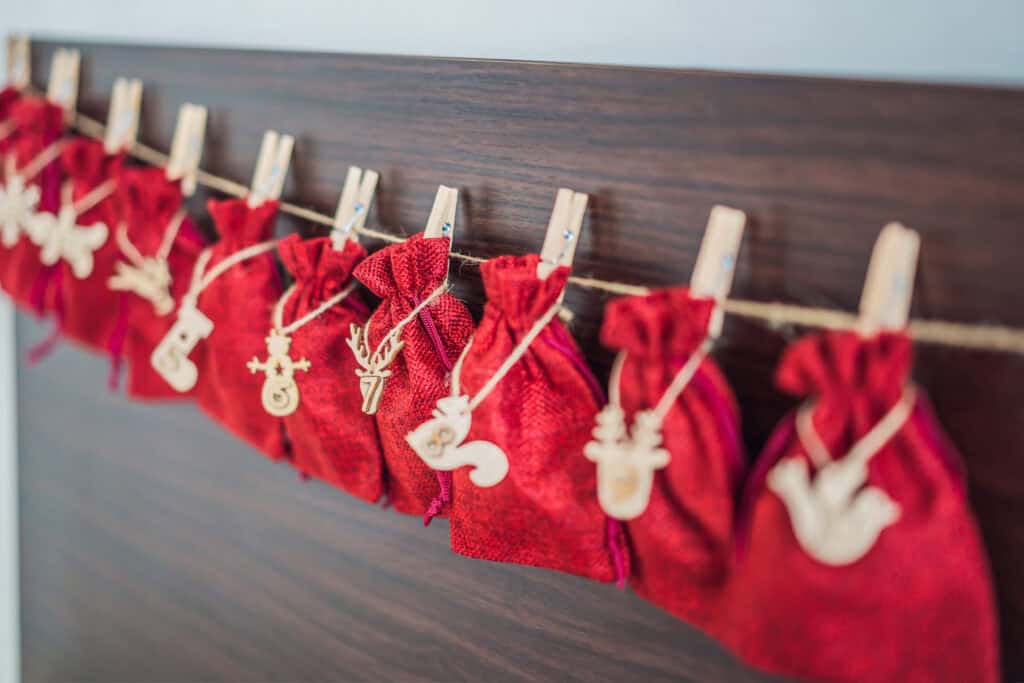Advent calendar of little red sacks with numbers in gold on them.