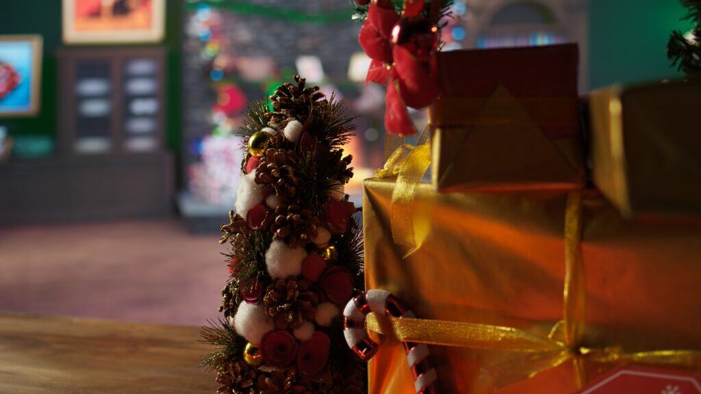 Festive ornaments and baubles shining in the Christmas lights at the North Pole, empty log cabin where Santa Claus creates gifts for children. Multicolored garlands on a tree in the workshop.